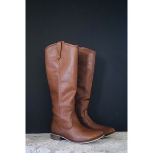 Tan rider boots with zipper on side.